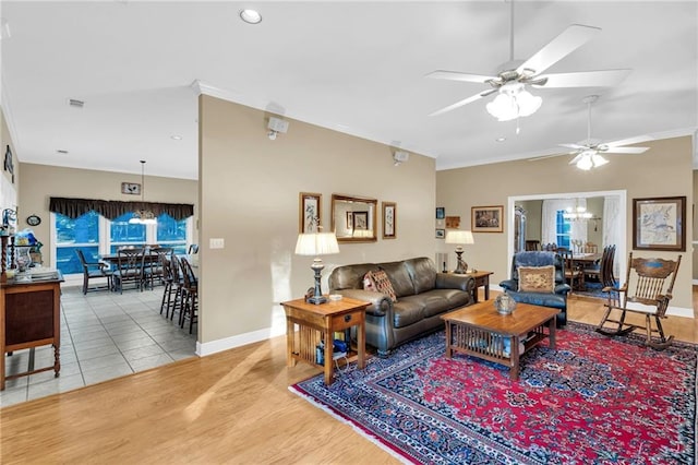 living room featuring crown molding, hardwood / wood-style floors, and ceiling fan