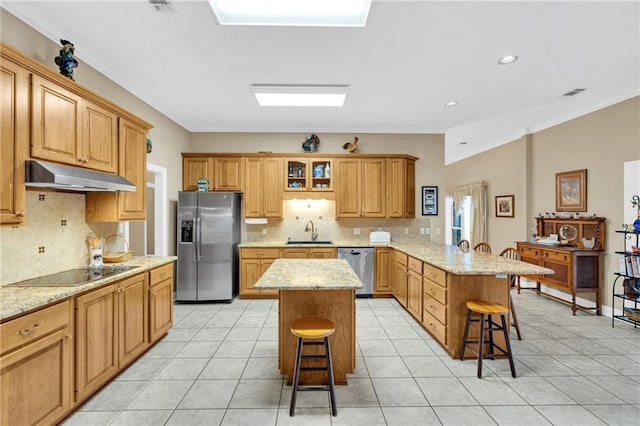 kitchen featuring sink, stainless steel appliances, kitchen peninsula, a kitchen bar, and a kitchen island