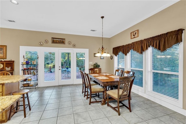 dining space with a notable chandelier, plenty of natural light, light tile patterned flooring, and french doors