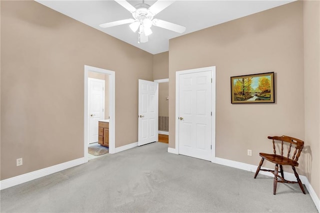 carpeted bedroom with ensuite bathroom and ceiling fan