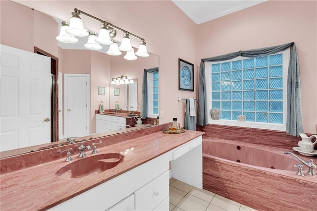 bathroom with a washtub, vanity, and tile patterned floors