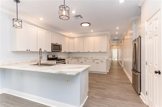 kitchen with kitchen peninsula, stainless steel appliances, white cabinetry, and hanging light fixtures