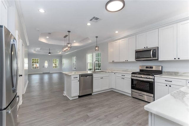 kitchen featuring hanging light fixtures, stainless steel appliances, white cabinets, and ceiling fan