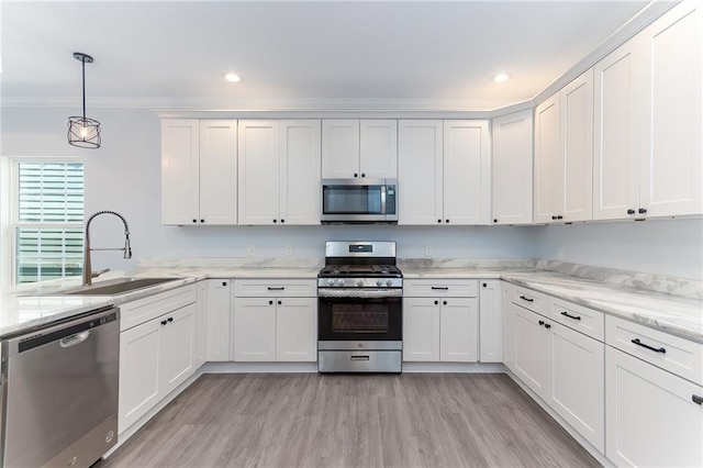 kitchen featuring decorative light fixtures, sink, white cabinetry, and stainless steel appliances