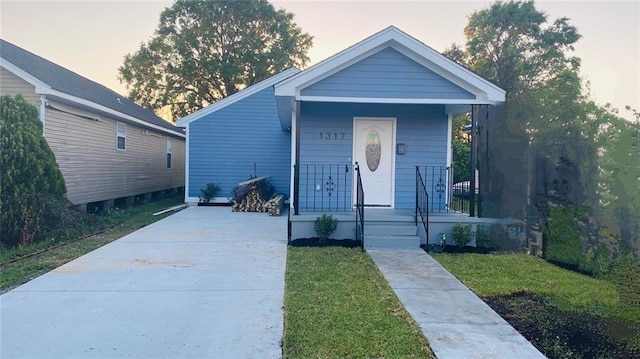 bungalow-style house featuring a yard and covered porch