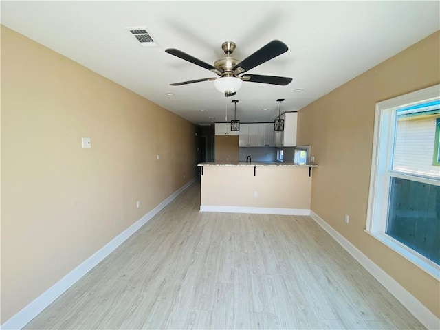 unfurnished living room with ceiling fan and light hardwood / wood-style floors