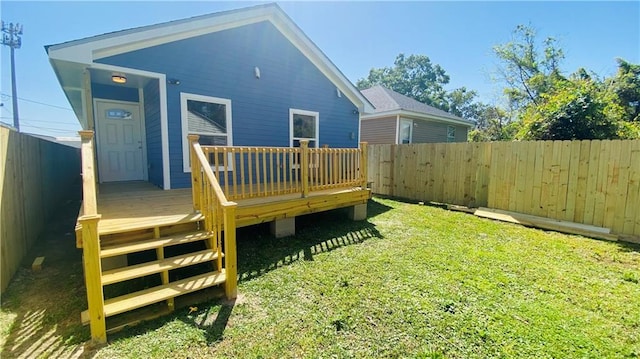 rear view of house with a yard and a deck