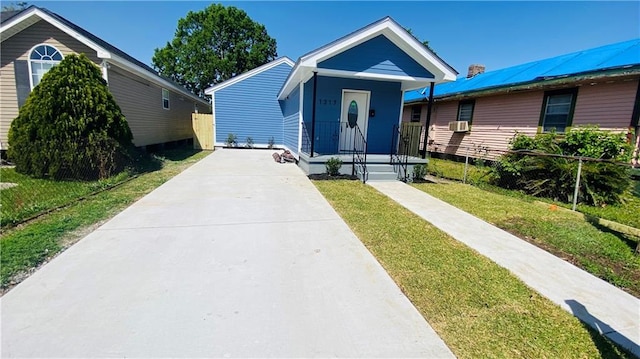 bungalow-style home featuring cooling unit and a front yard