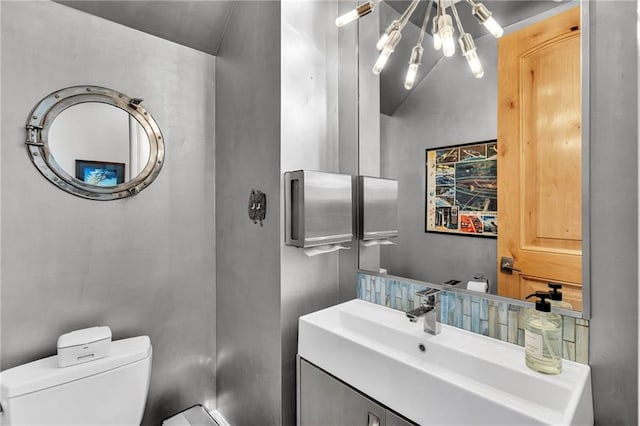 bathroom with vanity, toilet, and vaulted ceiling