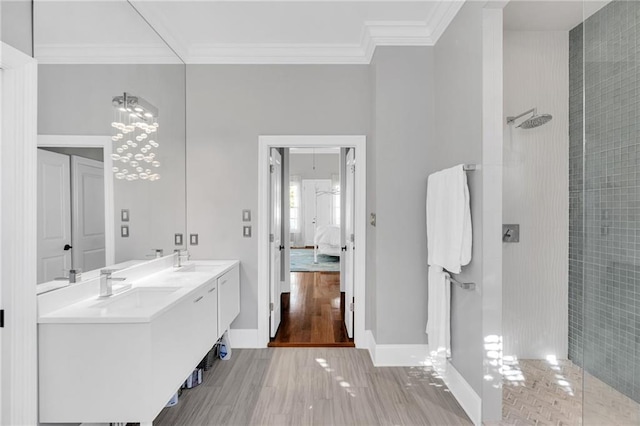 bathroom with hardwood / wood-style floors, vanity, walk in shower, and ornamental molding