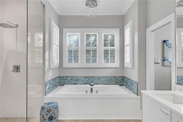 bathroom featuring shower with separate bathtub, vanity, an inviting chandelier, and ornamental molding