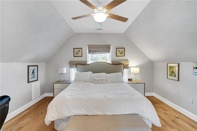 bedroom with ceiling fan, light hardwood / wood-style floors, and vaulted ceiling