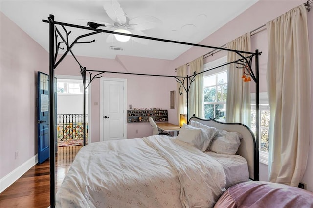 bedroom with ceiling fan, dark hardwood / wood-style flooring, access to outside, and multiple windows