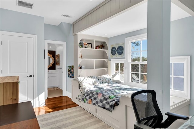 bedroom featuring ensuite bathroom and hardwood / wood-style floors