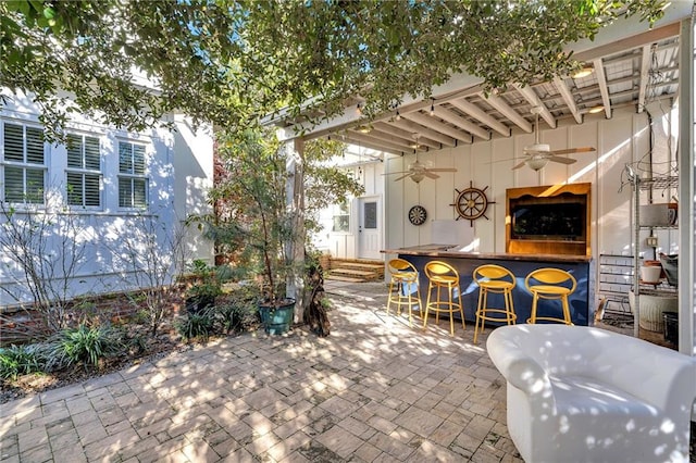 view of patio with ceiling fan and exterior bar