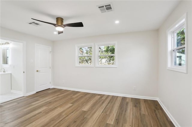 unfurnished room with light hardwood / wood-style floors, ceiling fan, and a healthy amount of sunlight