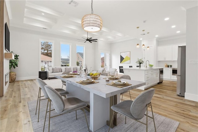 dining space with sink, wine cooler, ceiling fan, light wood-type flooring, and ornamental molding