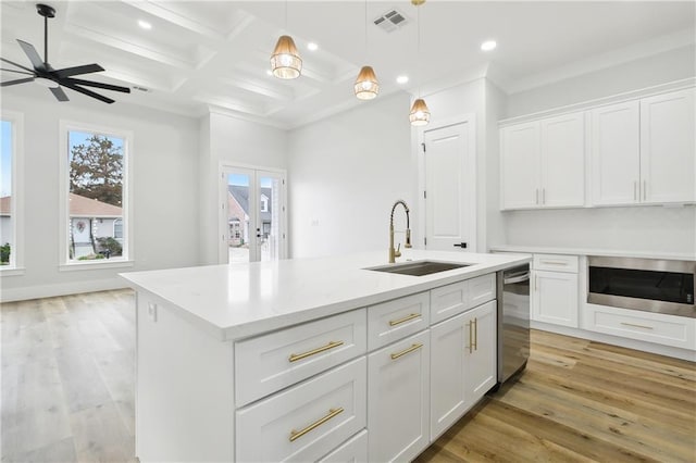 kitchen featuring a center island with sink, white cabinetry, light hardwood / wood-style floors, and sink