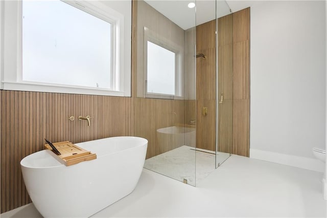 bathroom featuring separate shower and tub and wood walls