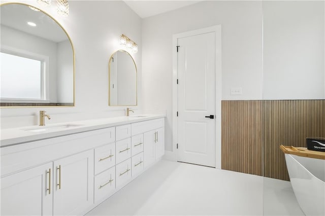 bathroom featuring a washtub and vanity