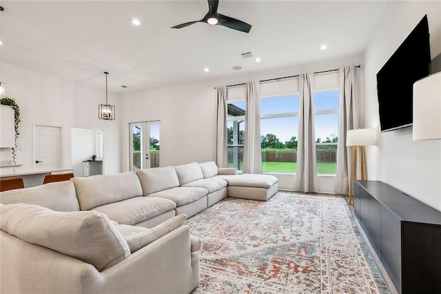 living room with ceiling fan with notable chandelier