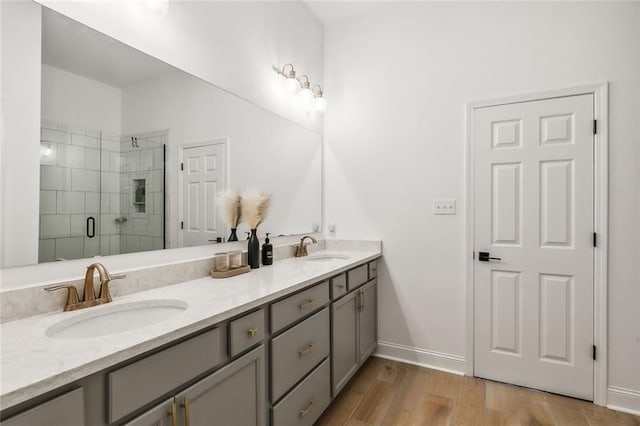 bathroom featuring hardwood / wood-style flooring, vanity, and a shower with shower door