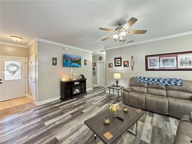 living room featuring hardwood / wood-style flooring, ceiling fan, and crown molding