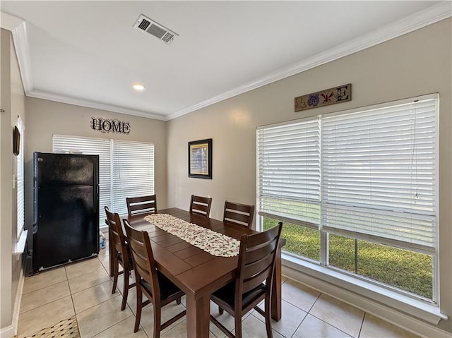 tiled dining area featuring crown molding