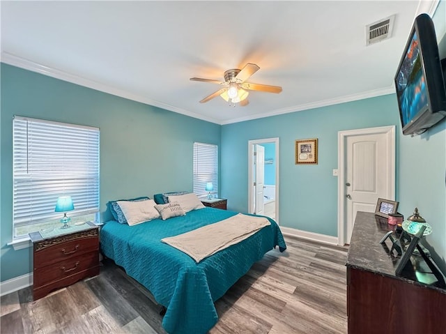 bedroom featuring ceiling fan, hardwood / wood-style floors, ensuite bathroom, and ornamental molding