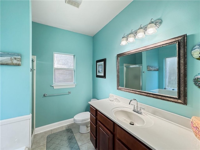 bathroom featuring tile patterned floors, toilet, vanity, and walk in shower