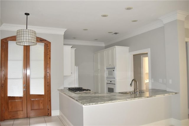 kitchen with kitchen peninsula, white appliances, white cabinets, and ornamental molding