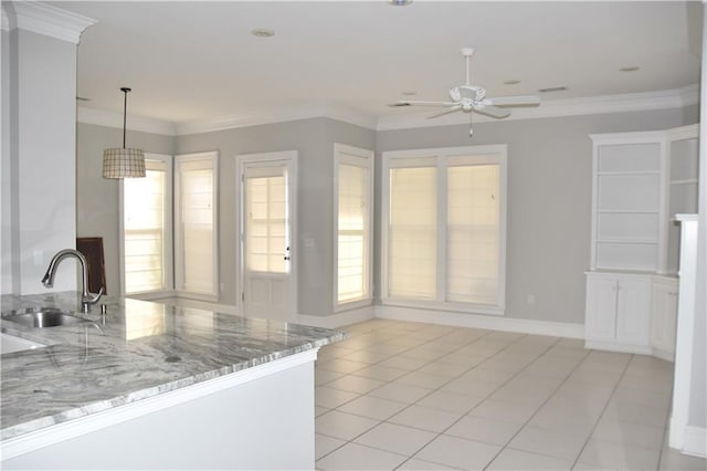 kitchen featuring a healthy amount of sunlight, crown molding, sink, and hanging light fixtures