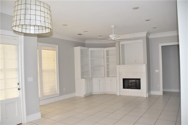 unfurnished living room featuring a tiled fireplace, ceiling fan, light tile patterned floors, and ornamental molding