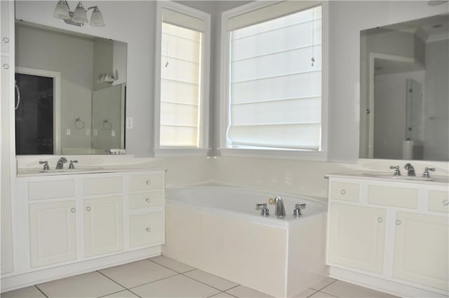 bathroom featuring tile patterned flooring, a washtub, and vanity