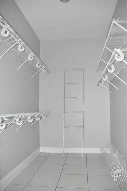 walk in closet with tile patterned floors