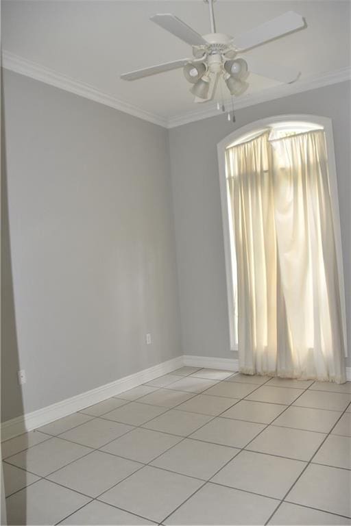 tiled spare room featuring ceiling fan and crown molding