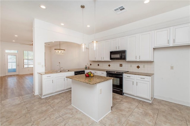 kitchen featuring white cabinetry, light stone counters, pendant lighting, black appliances, and ceiling fan with notable chandelier