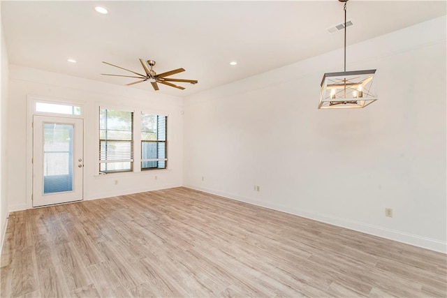 unfurnished living room with light hardwood / wood-style flooring and ceiling fan with notable chandelier