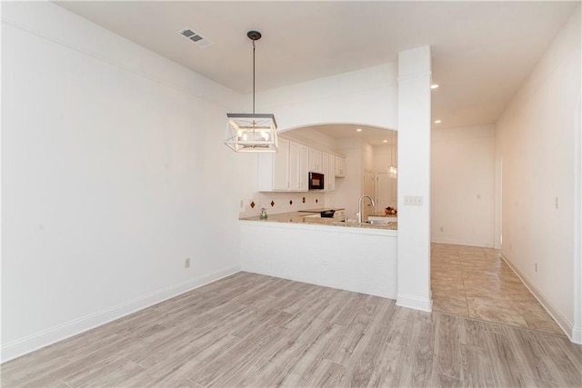 unfurnished living room featuring light wood-type flooring and sink