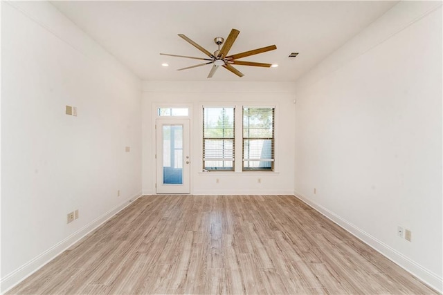 empty room with ceiling fan and light hardwood / wood-style floors