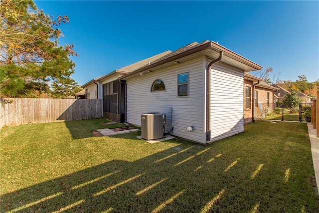 back of property with a lawn and central AC