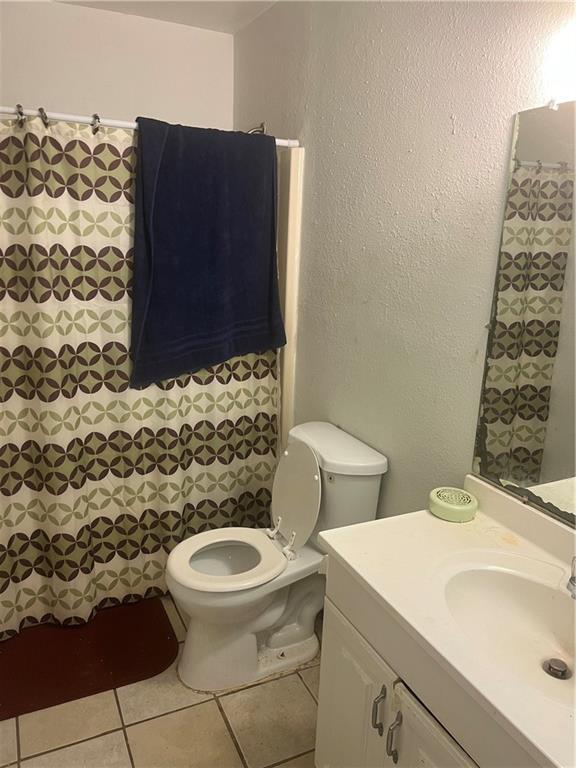 bathroom featuring tile patterned flooring, vanity, and toilet