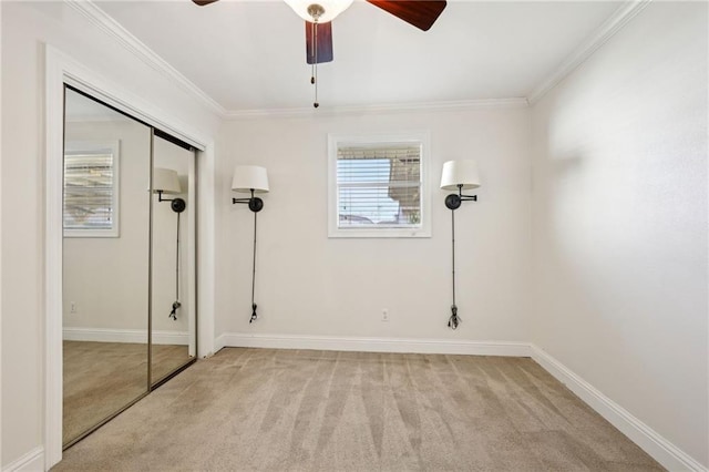 unfurnished bedroom featuring ceiling fan, light colored carpet, ornamental molding, and a closet