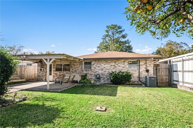 rear view of house with central AC unit, a yard, and a patio