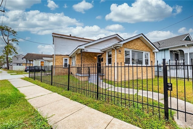 2501 Sage St, New Orleans, LA 70122 - view of front facade with a front lawn, brick siding, and a fenced front yard