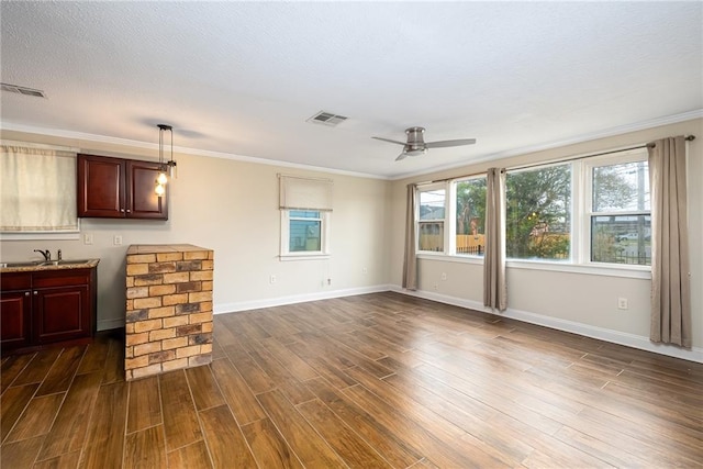 living room featuring ceiling fan, sink, dark hardwood / wood-style flooring, crown molding, and a textured ceiling