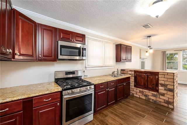 kitchen with sink, dark hardwood / wood-style floors, crown molding, pendant lighting, and appliances with stainless steel finishes