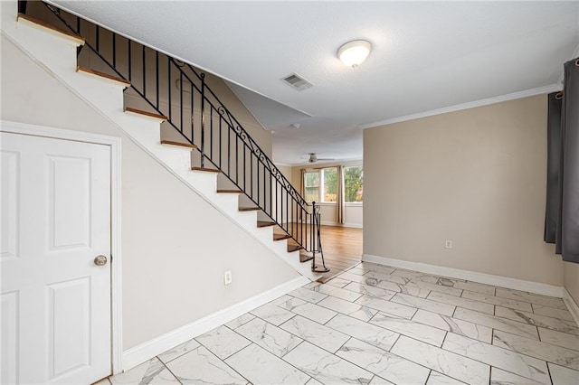 stairway with ceiling fan, a textured ceiling, and ornamental molding