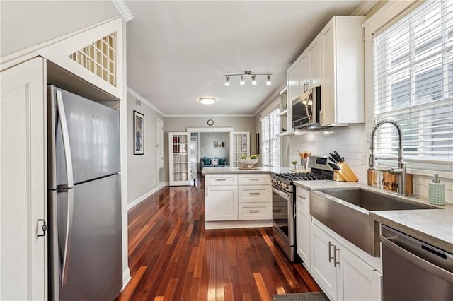 kitchen with white cabinetry, sink, stainless steel appliances, and kitchen peninsula