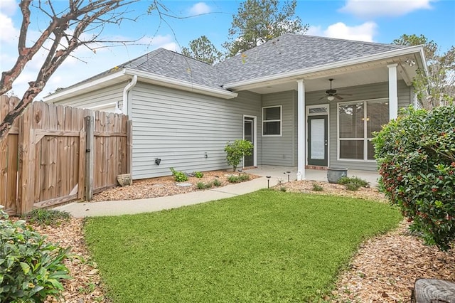 rear view of house with a yard and ceiling fan